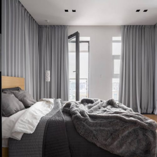 Luxury bedroom interior with double bed and gray window curtains